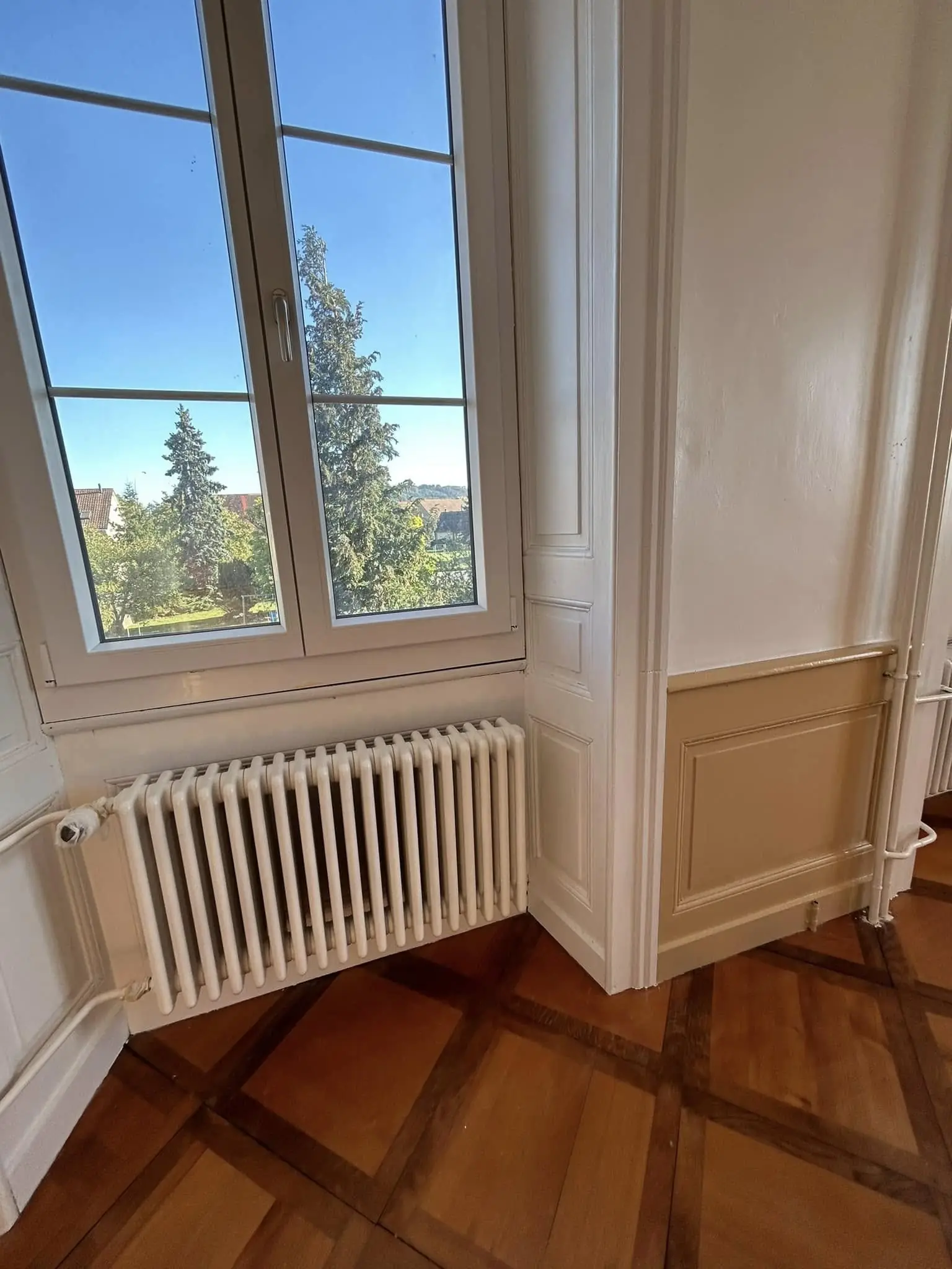 Fenêtre repeinte en blanc au-dessus d'un soubassement beige