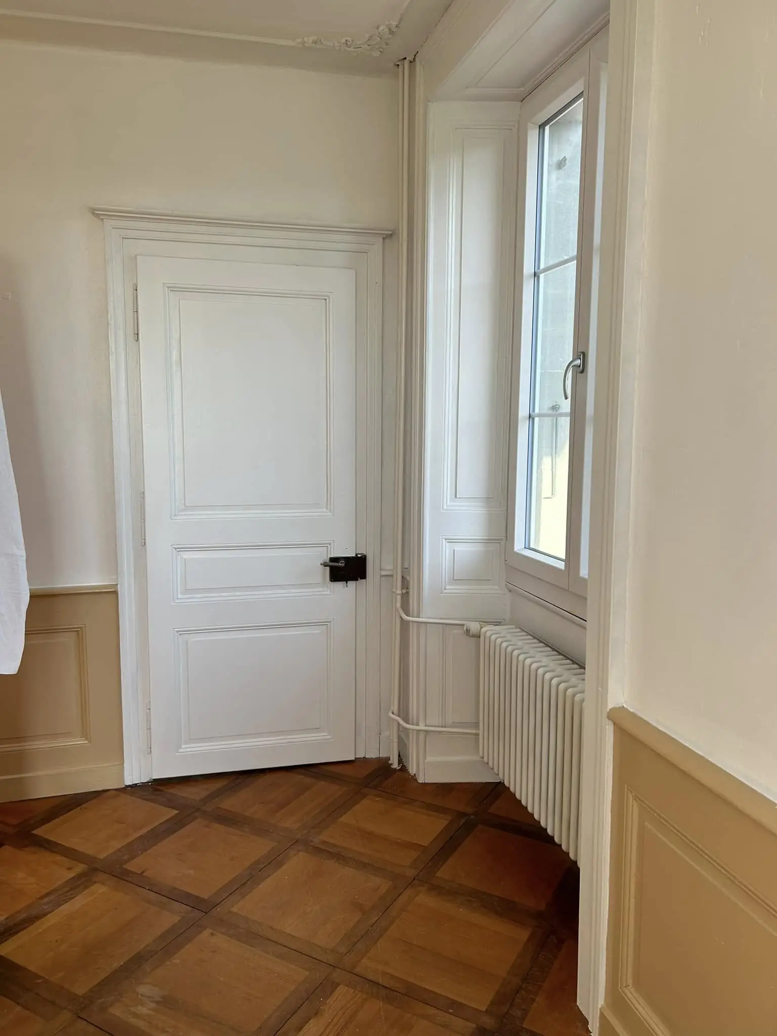 Porte de palier laquée blanche et parquet en point de Hongrie