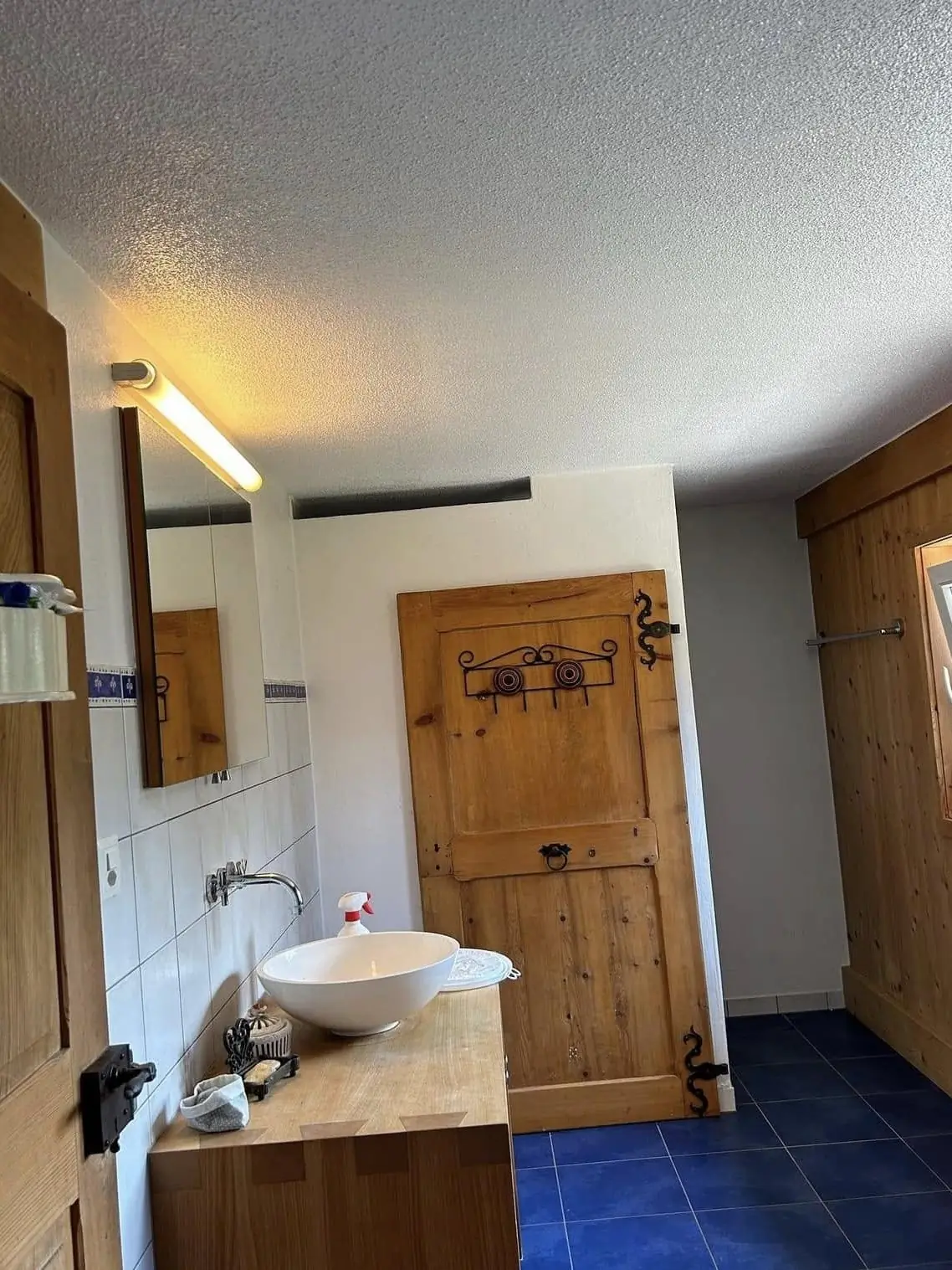 Salle de bain avec porte en bois massif et murs repeints